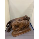 TWO TREEN CARVINGS OF WILD CATS ONE WITH A SNAKE AS PRAY