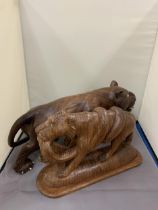 TWO TREEN CARVINGS OF WILD CATS ONE WITH A SNAKE AS PRAY