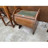 AN ART DECO MAHOGANY PIANO STOOL WITH CIRCULAR ENDS AND HINGED SEAT