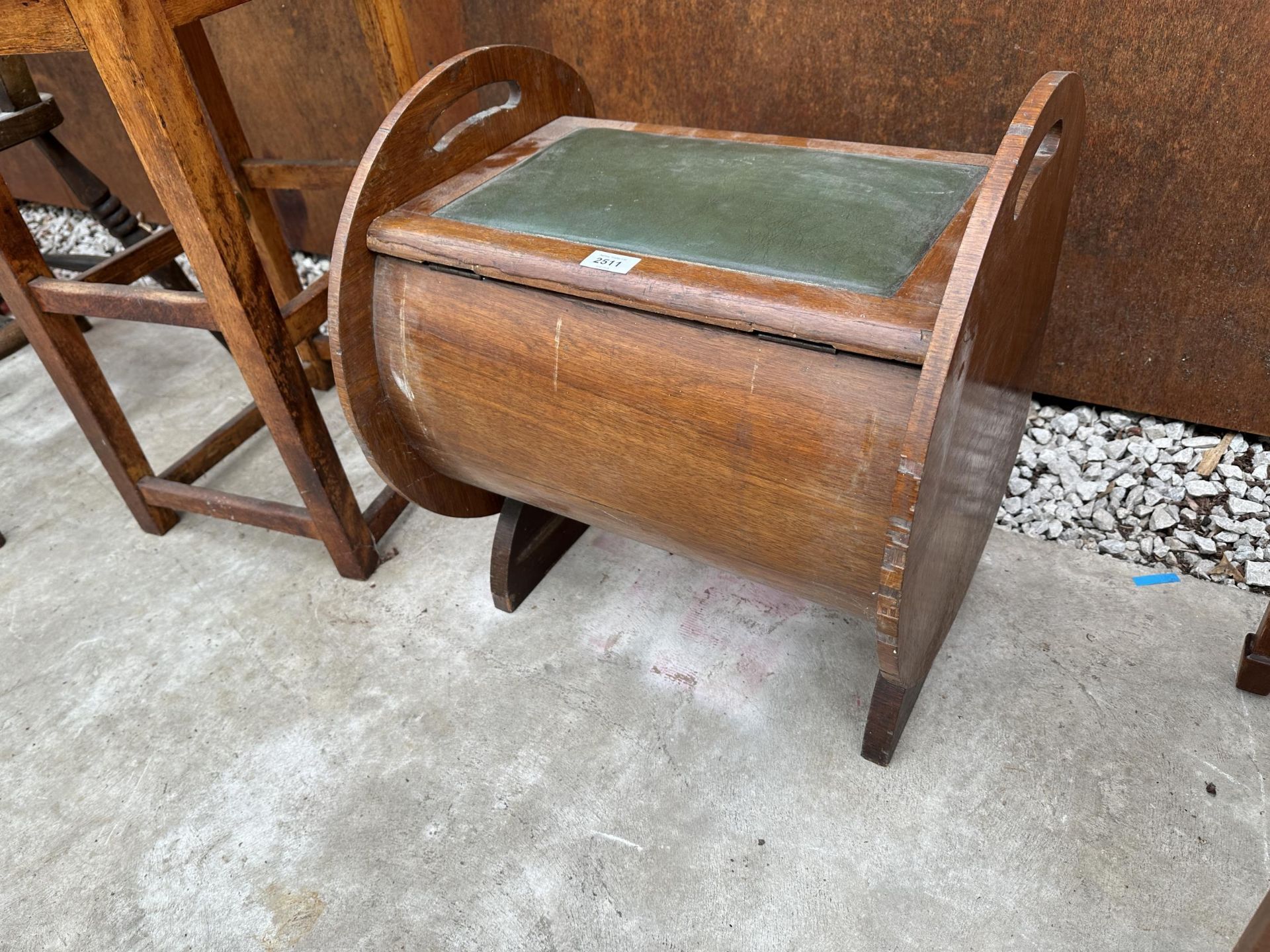 AN ART DECO MAHOGANY PIANO STOOL WITH CIRCULAR ENDS AND HINGED SEAT