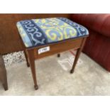 AN EDWARDIAN MAHOGANY PIANO STOOL WITH HINGED TAPESTRY SEAT, TAPERED SUPPORTS AND SPADE FEET