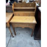 AN ARTS AND CRAFTS STYLE OAK LADIES' WRITING TABLE WITH OPEN SHELVES AND THREE DRAWERS - 27" WIDE