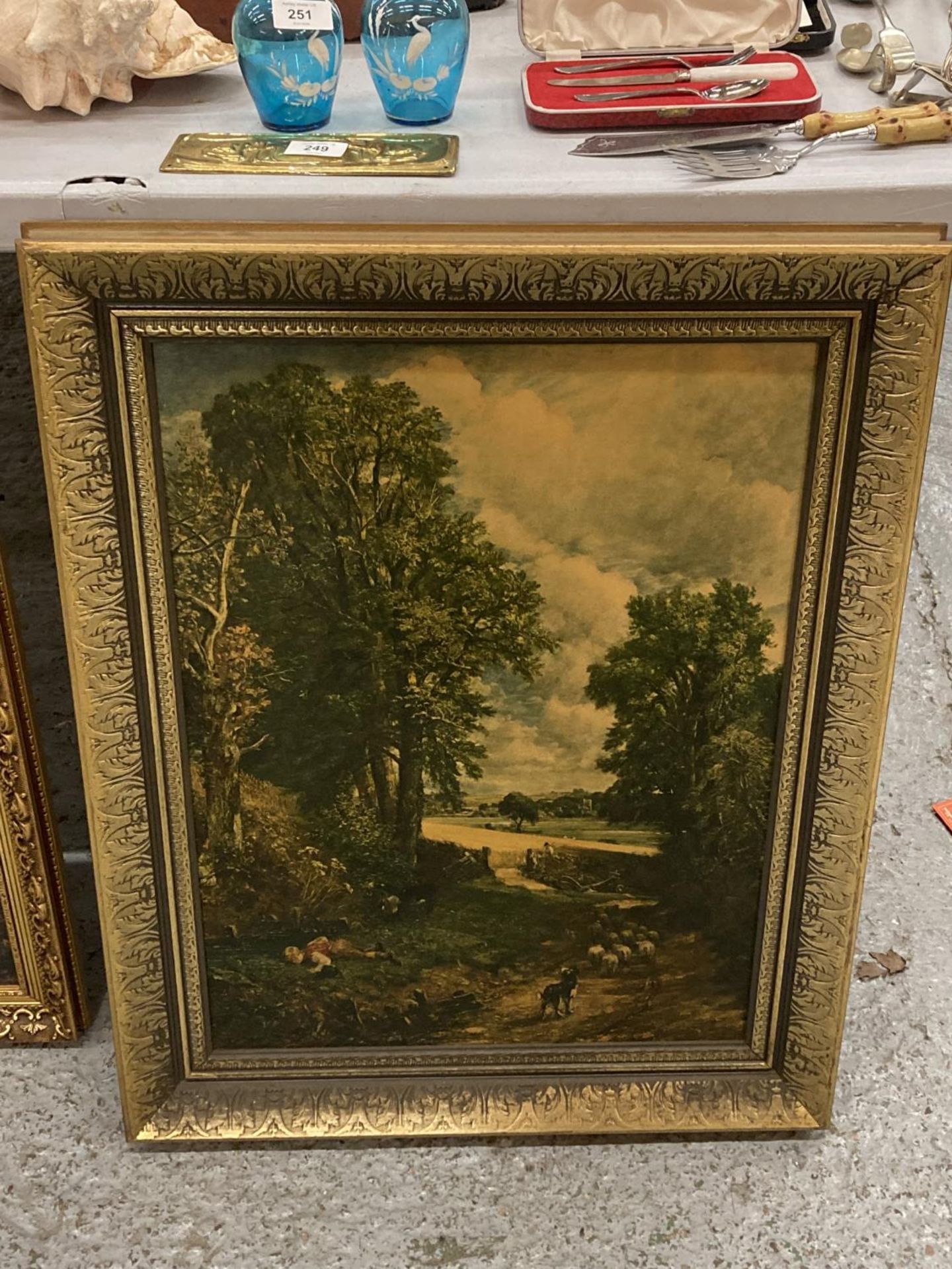 A GILT FRAMED PRINT OF A CONSTABLE BOY DRINKING WITH DOG AND SHEEP