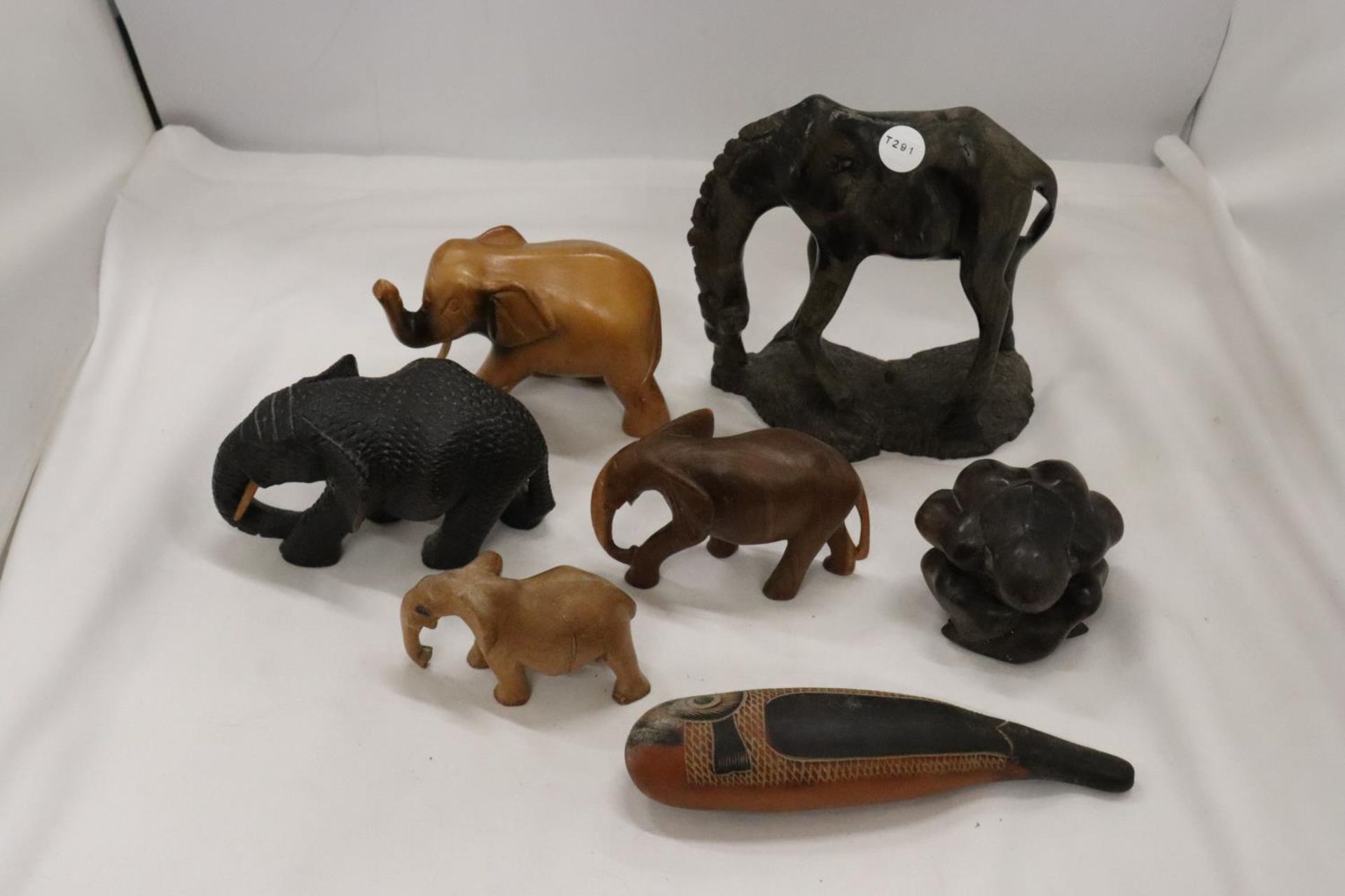 A QUANTITY OF WOODEN CARVED ANIMALS TO INCLUDE ELEPHANTS, A GIRAFFE, ETC