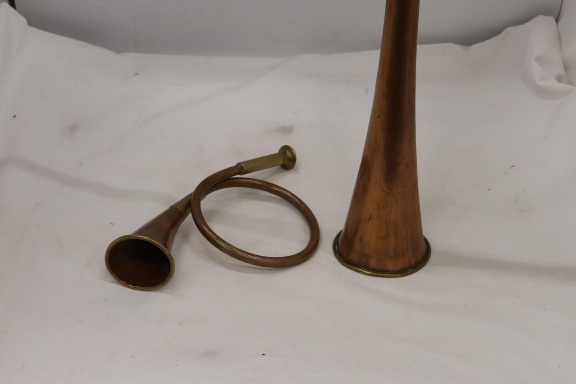 A VINTAGE COPPER AND BRASS COACHING HORN PLUS A COPPER AND BRASS HUNTING HORN