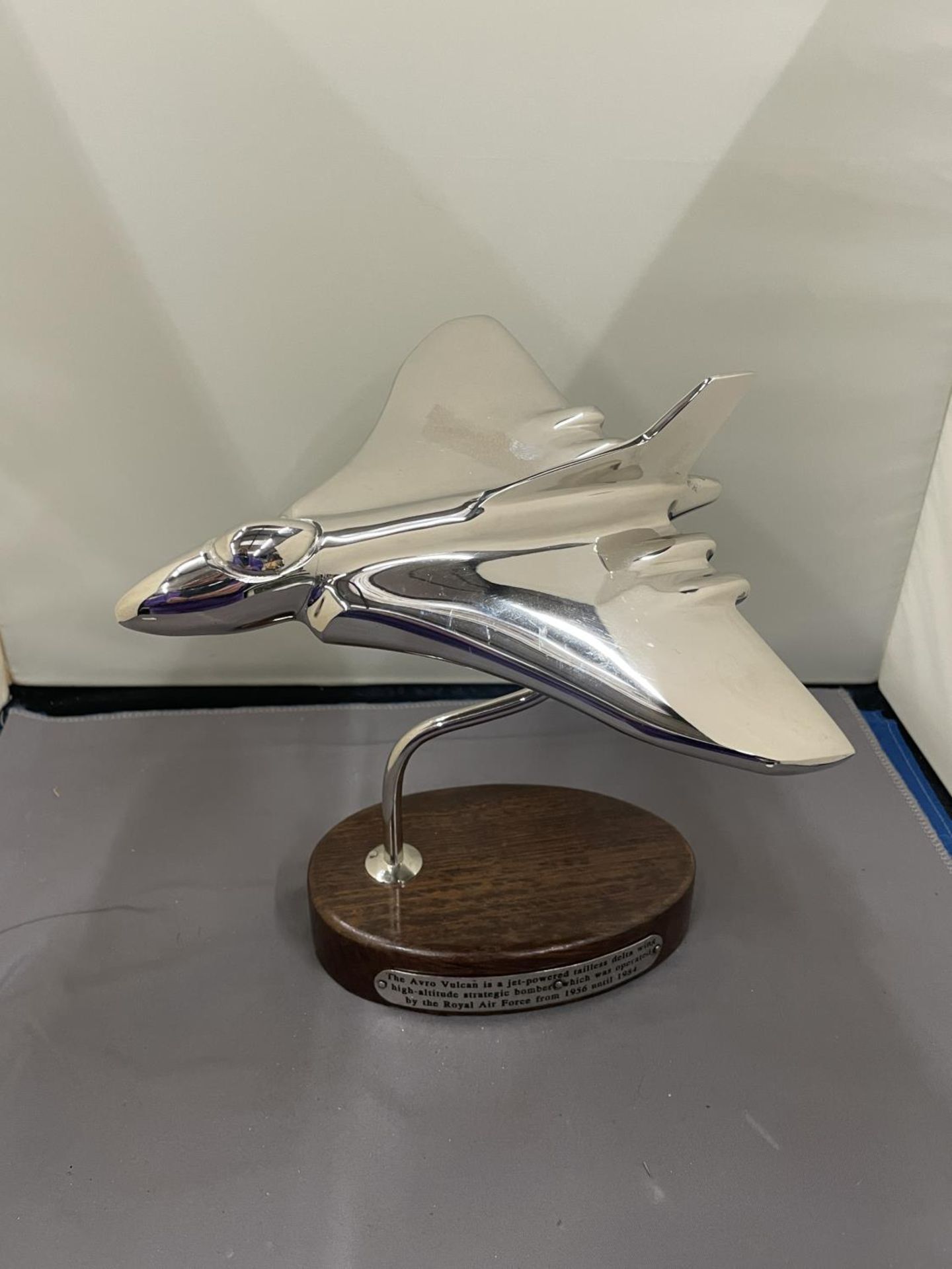 A CHROME VULCAN BOMBER ON A WOODEN BASE