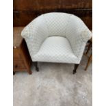 AN EDWARDIAN UPHOLSTERED TUB CHAIR ON TAPERED LEGS