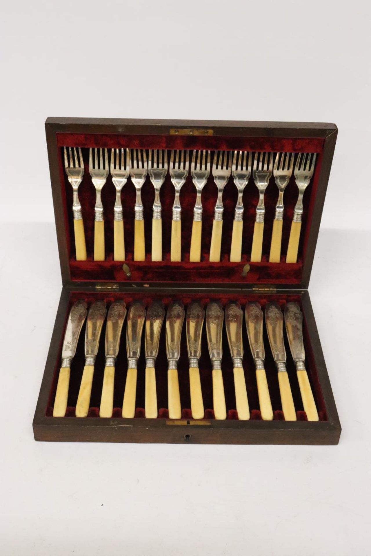 A VINTAGE SET OF FISH KNIVES AND FORKS IN A MAHOGANY BOX WITH HALLMARKED SILVER COLLARS