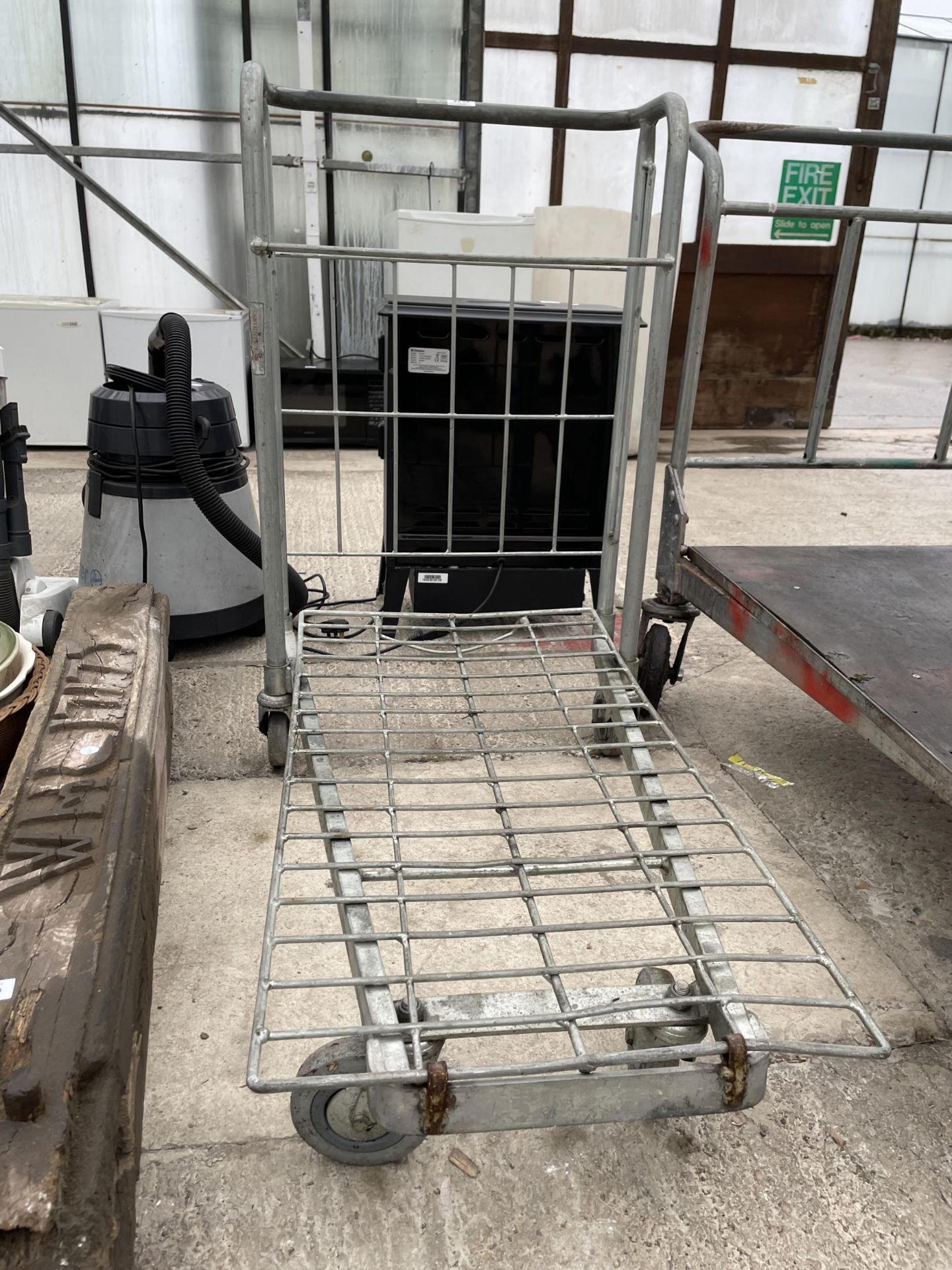 A METAL FOUR WHEELED MARKET GARDENERS TROLLEY IN WORKING ORDER BUT NO WARRANTY