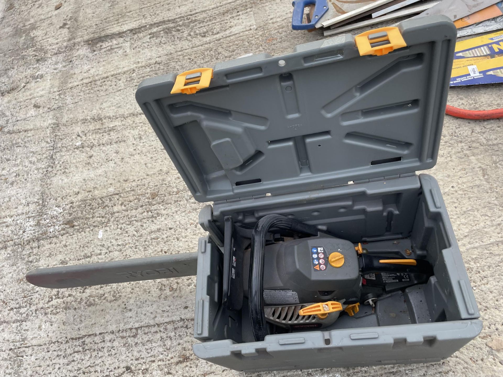 A RYOBI PETROL CHAINSAW WITH CARRY CASE