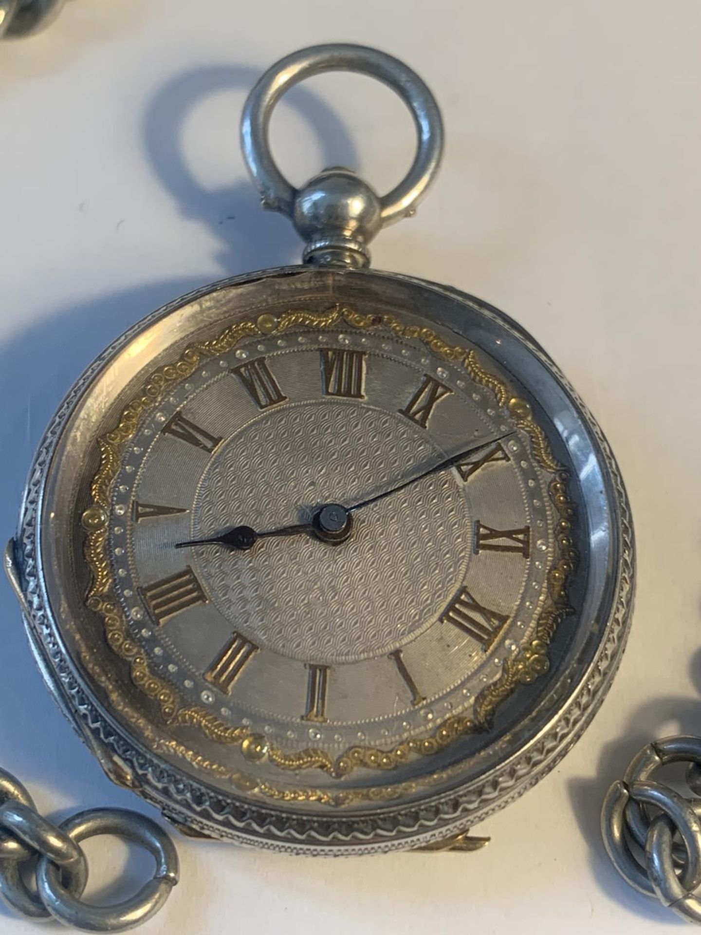 A MARKED FINE SILVER POCKET WATCH WITH DECORATIVE FACE AND A CHAIN - Image 2 of 6