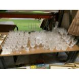 A LARGE QUANTITY OF GLASSES TO INCLUDE WINE, CHAMPAGNE FLUTES, SHERRY, BRANDY, TUMBLERS, ETC PLUS