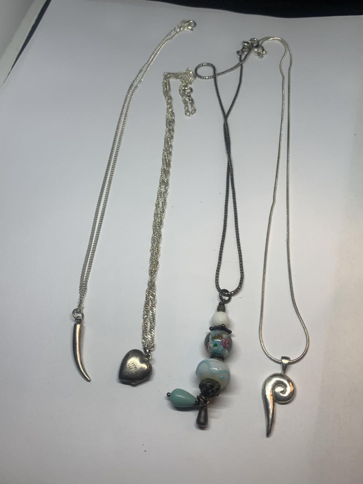 FOUR SILVER NECKLACES WITH PENDANTS