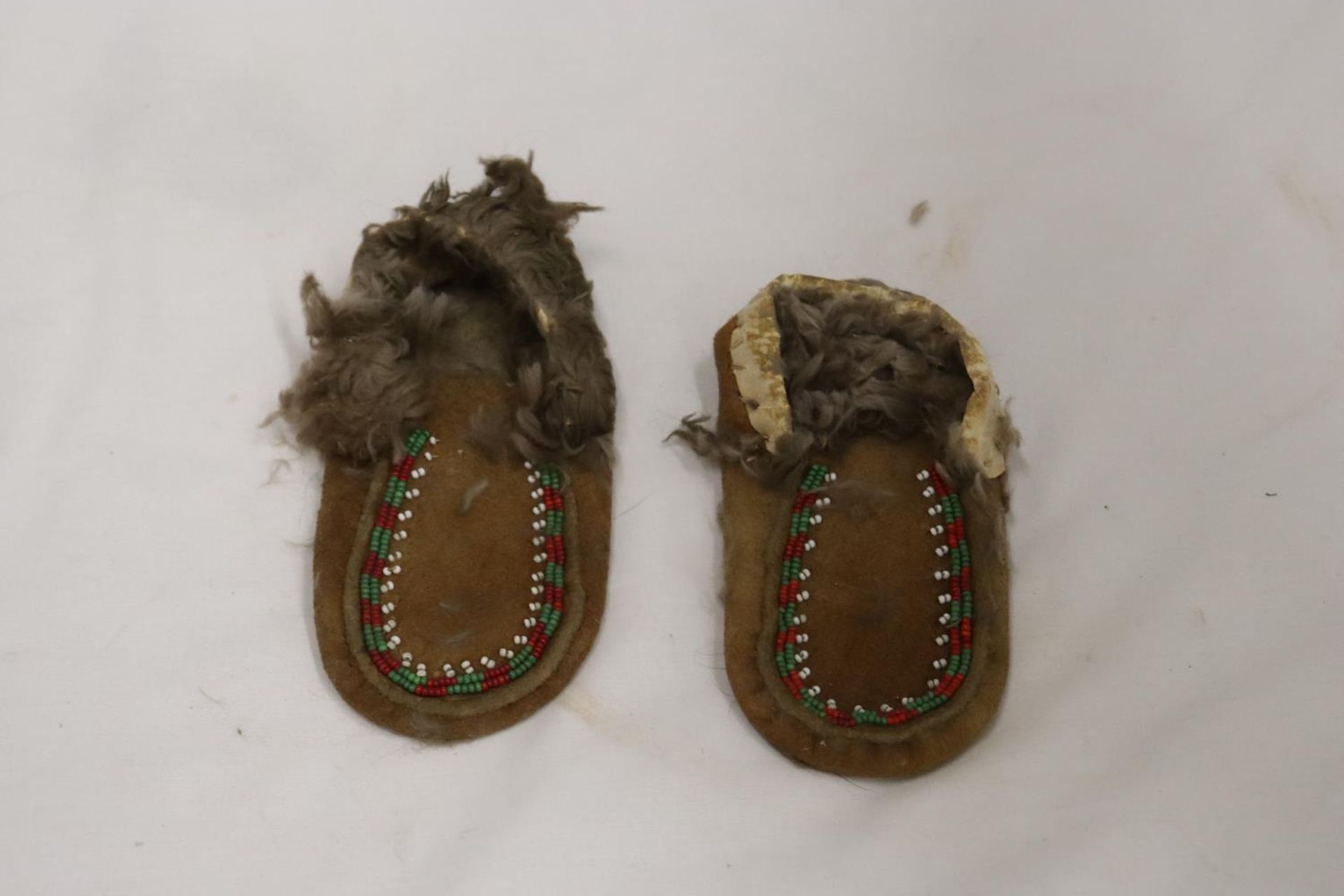 A PAIR OF SMALL CHILD'S NORTH AMERICAN MOCCASSINS WITH BEAD WORK TO THE FRONT