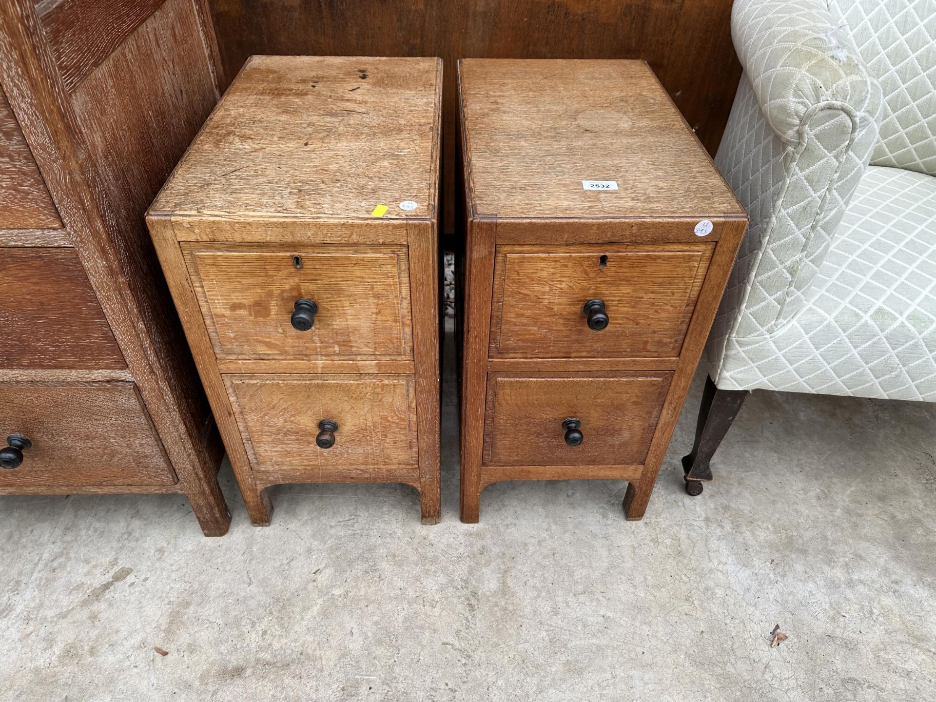 A PAIR OF HEAL AND SON (LONDON) LIMED OAK TWO DRAWER BEDSIDE CHEST WITH EBONISED KNOBS, PLEASE