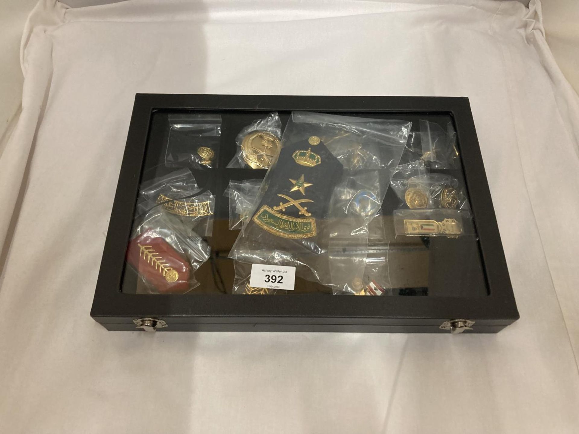 A DISPLAY CASE CONSTAINING TWENTY FIVE GULF MEDALS AND BADGES INCLUDING A PAIR OF SAUDI ARMY