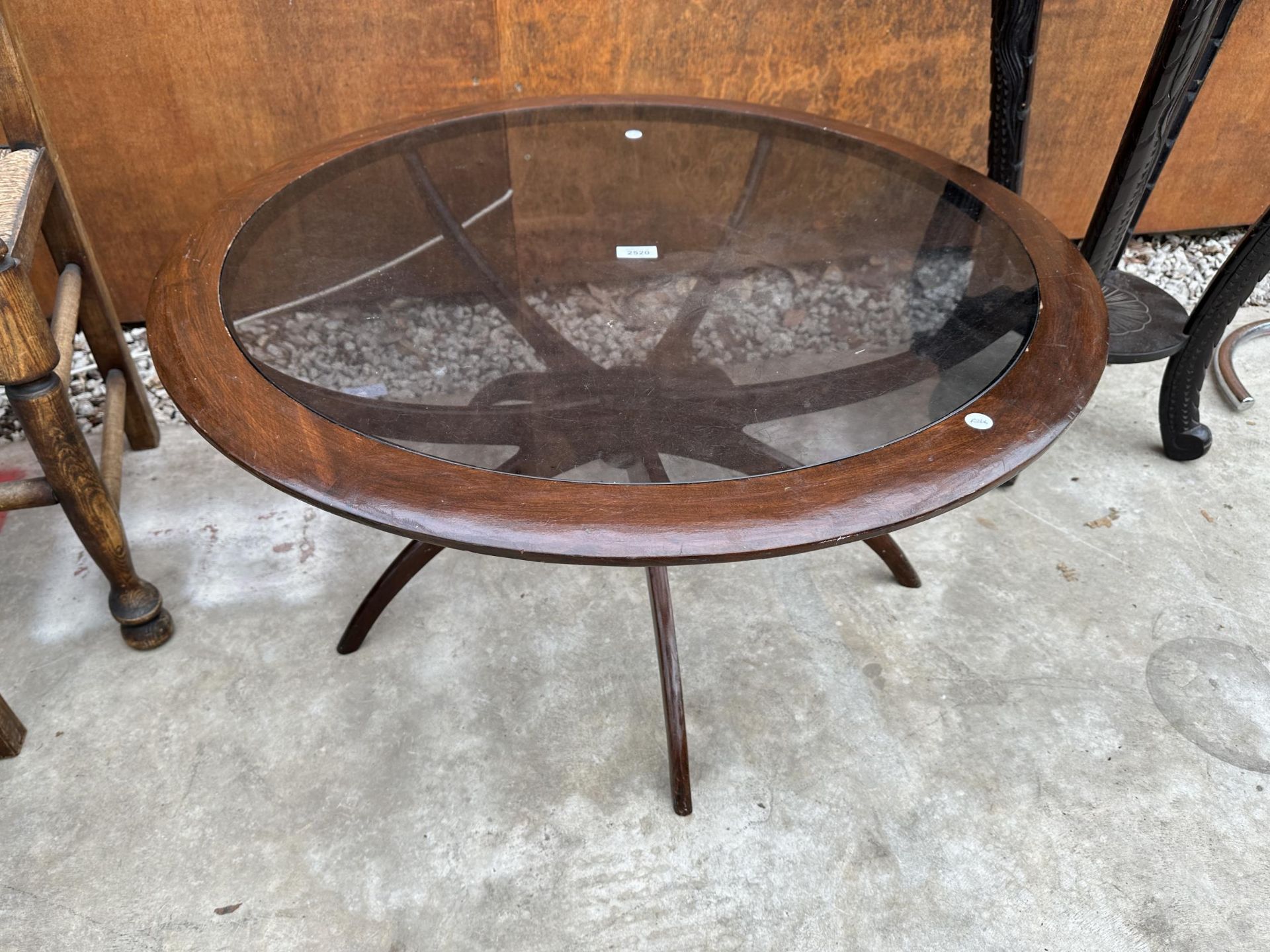 A RETRO CIRCULAR TEAK SPIDER LEG COFFEE TABLE WITH INSET GLASS TOP