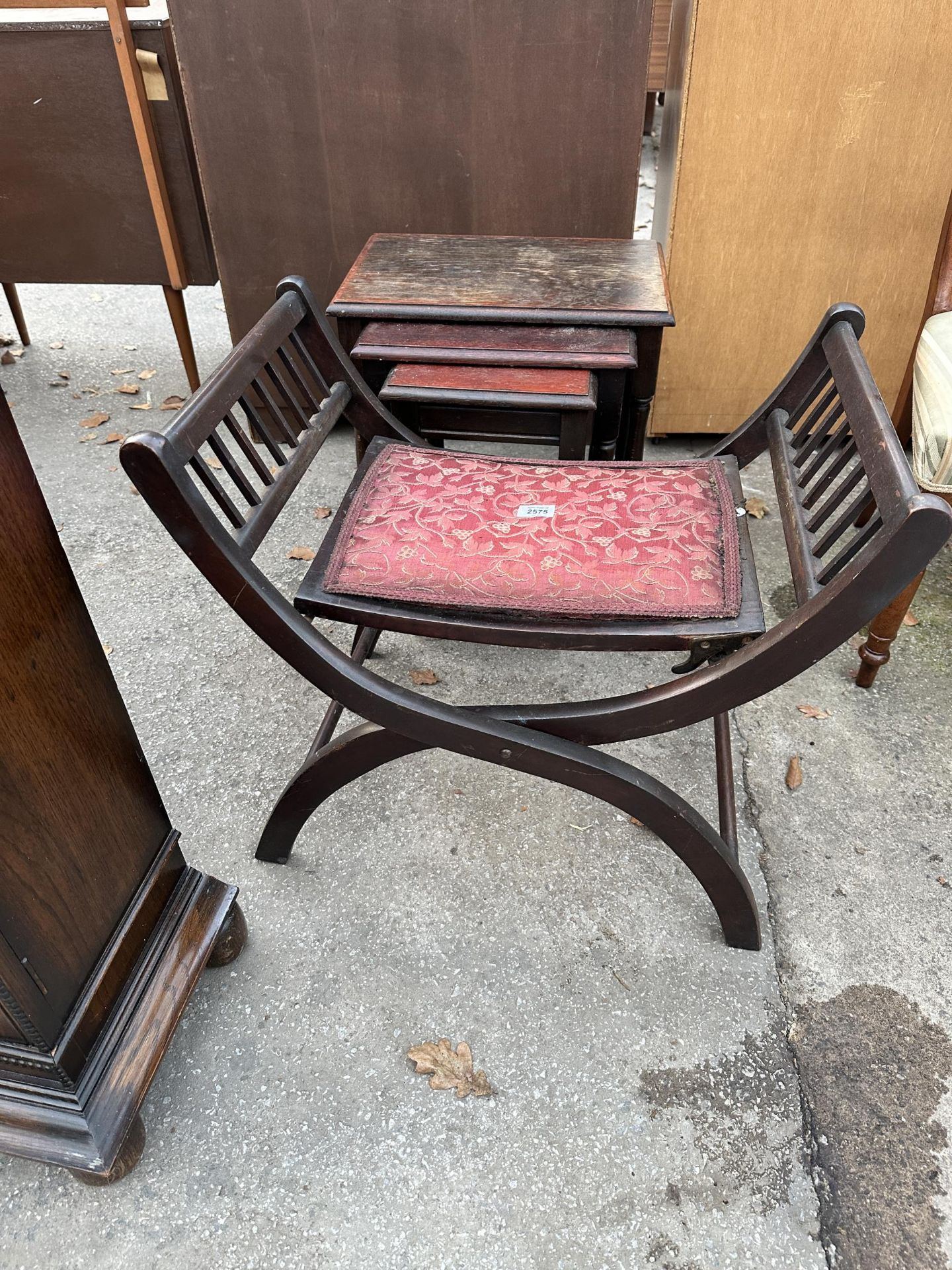 AN ARTS AND CRAFTS FOLDING STOOL AND NEST OF THREE TABLES