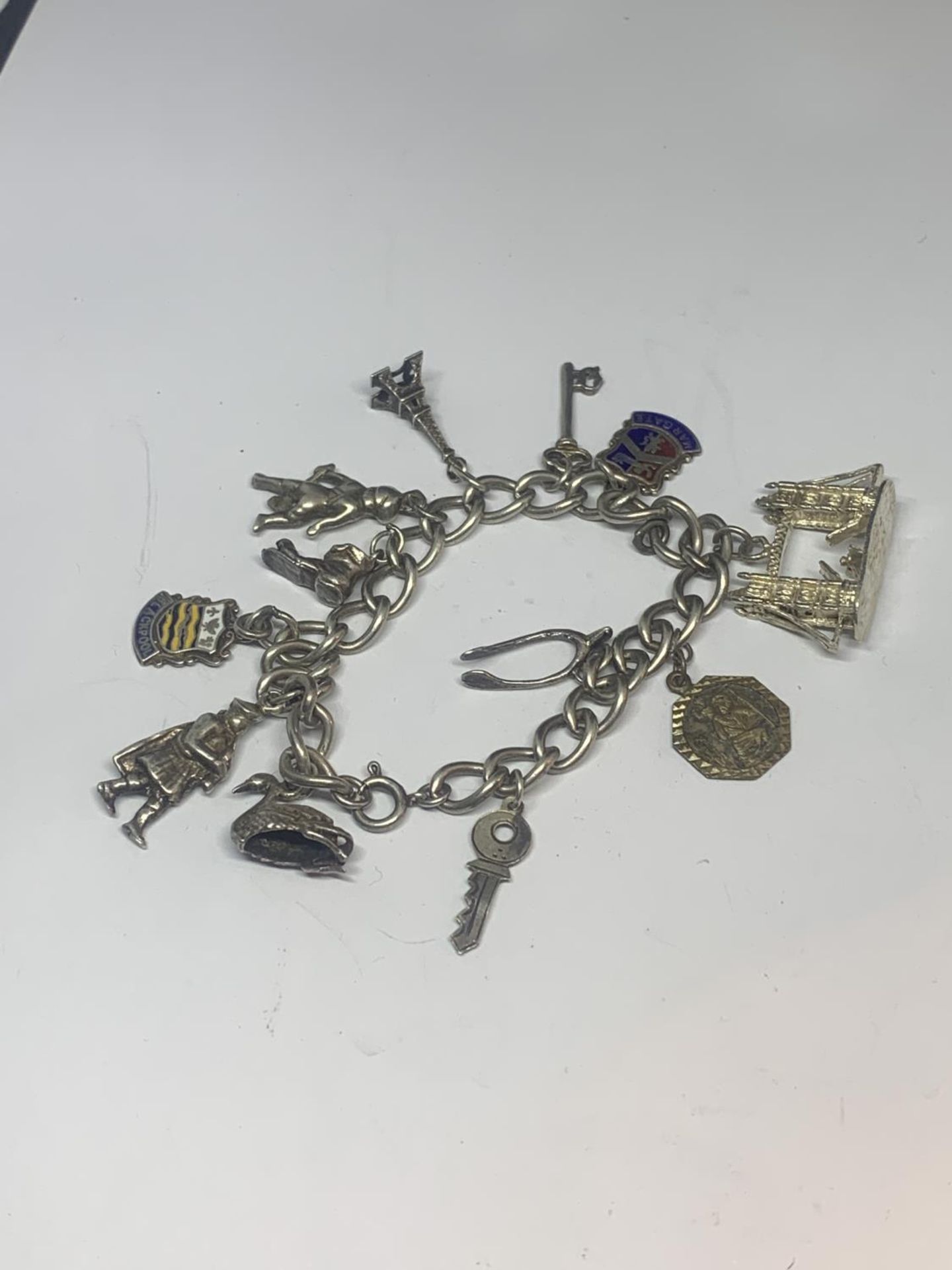 A SILVER CHARM BRACELET WITH TWELVE VARIOUS CHARMS