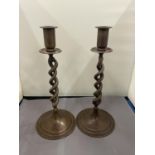 A PAIR OF TWISTED BRONZE CANDLESTICKS