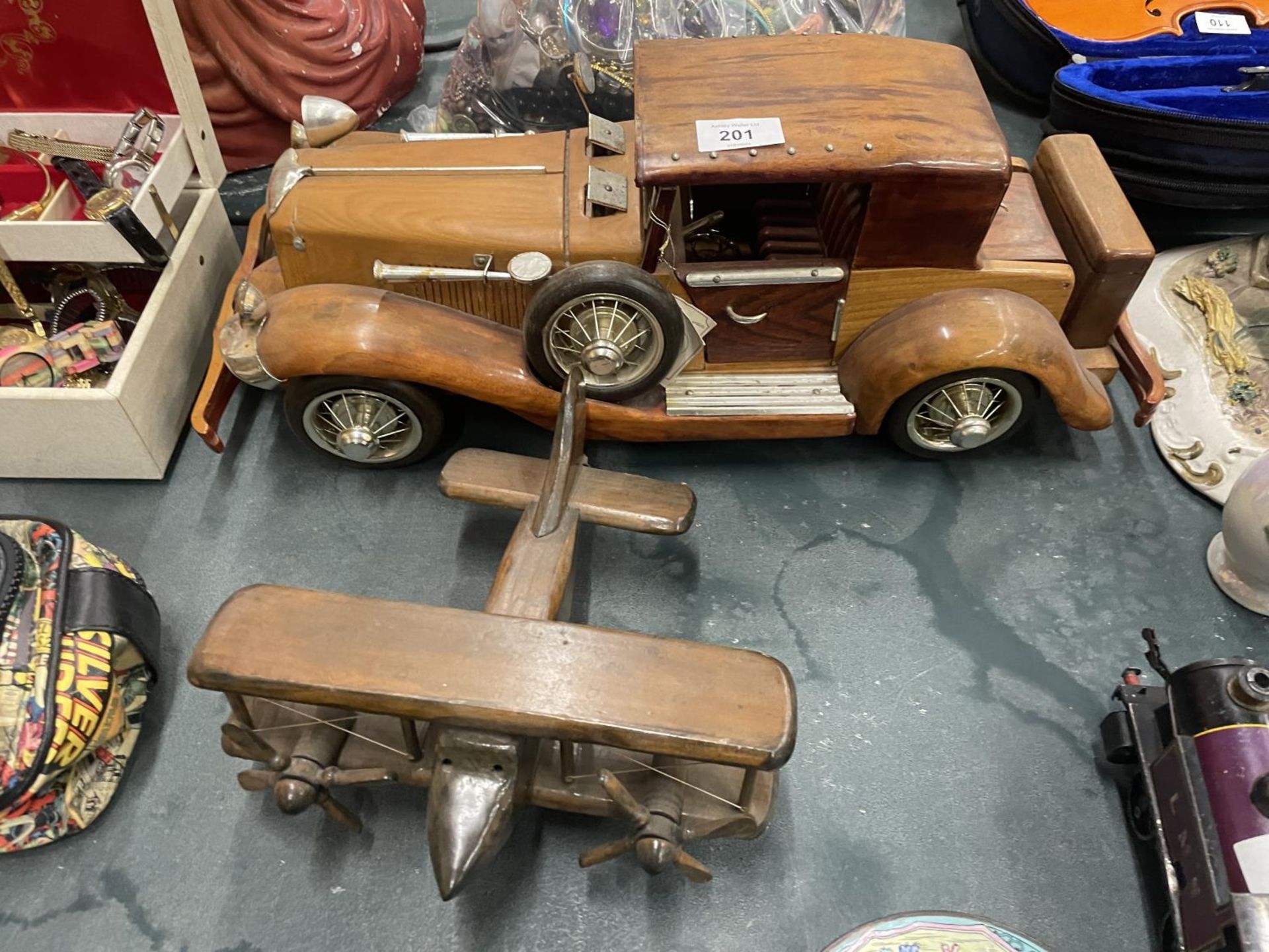 A LARGE WOODEN MODEL OF A CAR PLUS A SMALLER MODEL OF A BI-PLANE