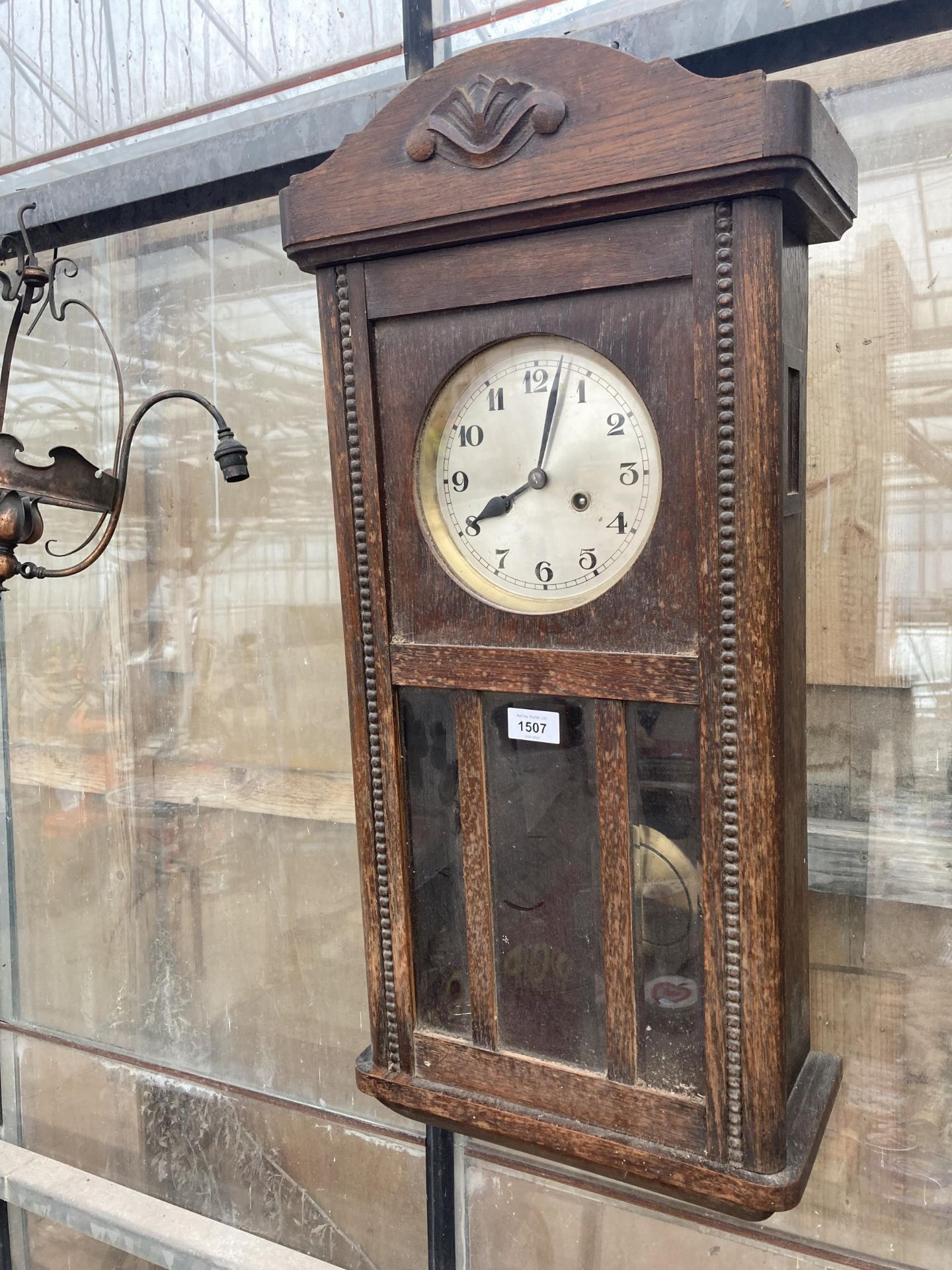 A VINTAGE OAK CASED CHIMING WALL CLOCK