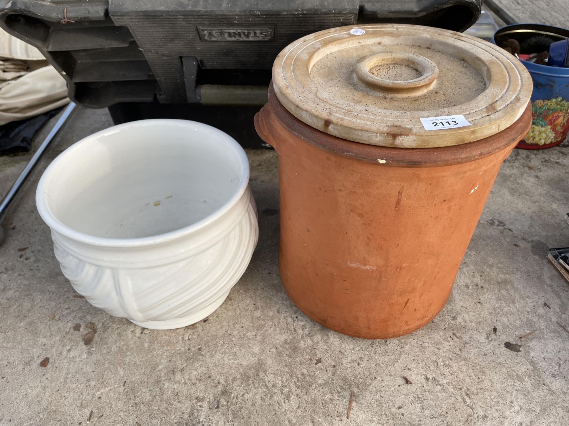 A TERRACOTTA LIDDED POT AND A FURTHER CERAMIC PLANTER