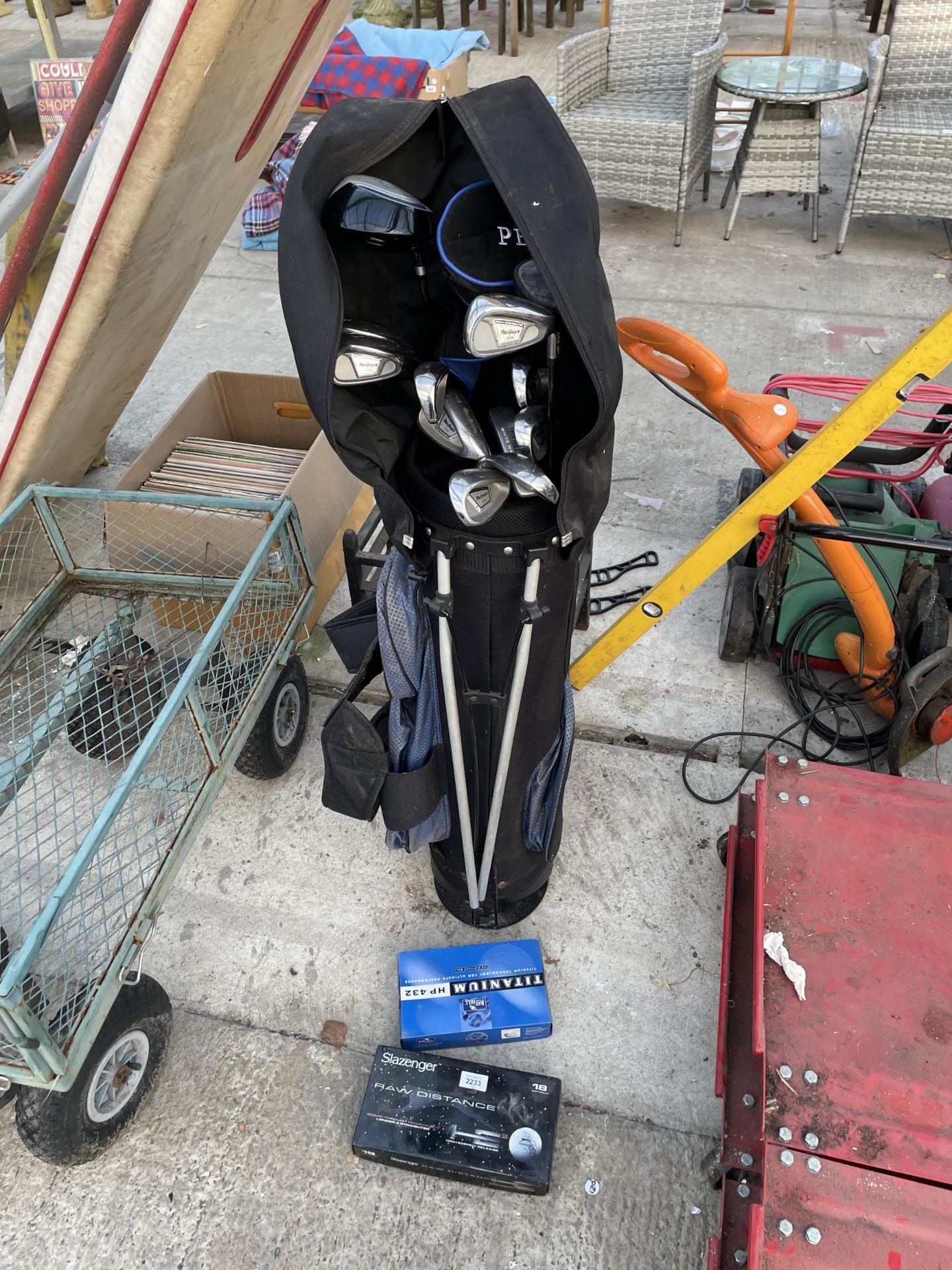 A GOLF BAG WITH GOLF BALLS AND AN ASSORTMENT OF CLUBS TO INCLUDE MCGREGOR AND A PATRON DRIVER ETC