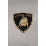 A TRIANGULAR BLACK AND GOLD CAST METAL LAMBORGHINI SIGN, 21CM X 18CM