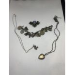 FOUR ITEMS TO INCLUDE TWO SILVER NECKLACES WITH PENDANTS, A CHARM BRACELET WITH TWELVE CHARMS AND