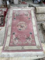 A PINK PATTERNED FRINGED RUG AND A SMALL RED PATTERNED RUG