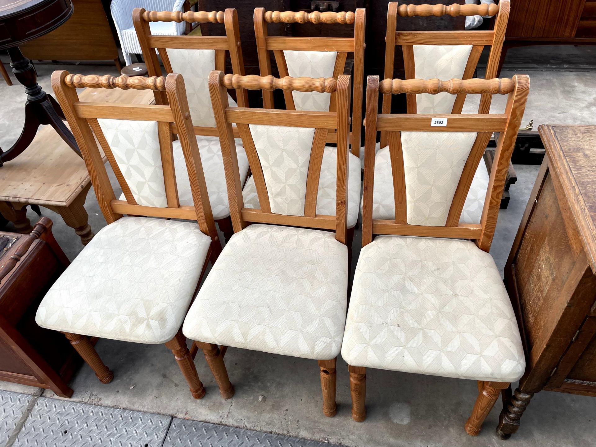 A SET OF FOUR MODERN PINE DINING CHAIRS WITH UPHOLSTERED SEATS AND BACKS