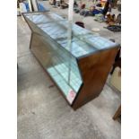 A VINTAGE WOODEN AND GLASS SHOP DISPLAY UNIT WITH INVERTED FRONT