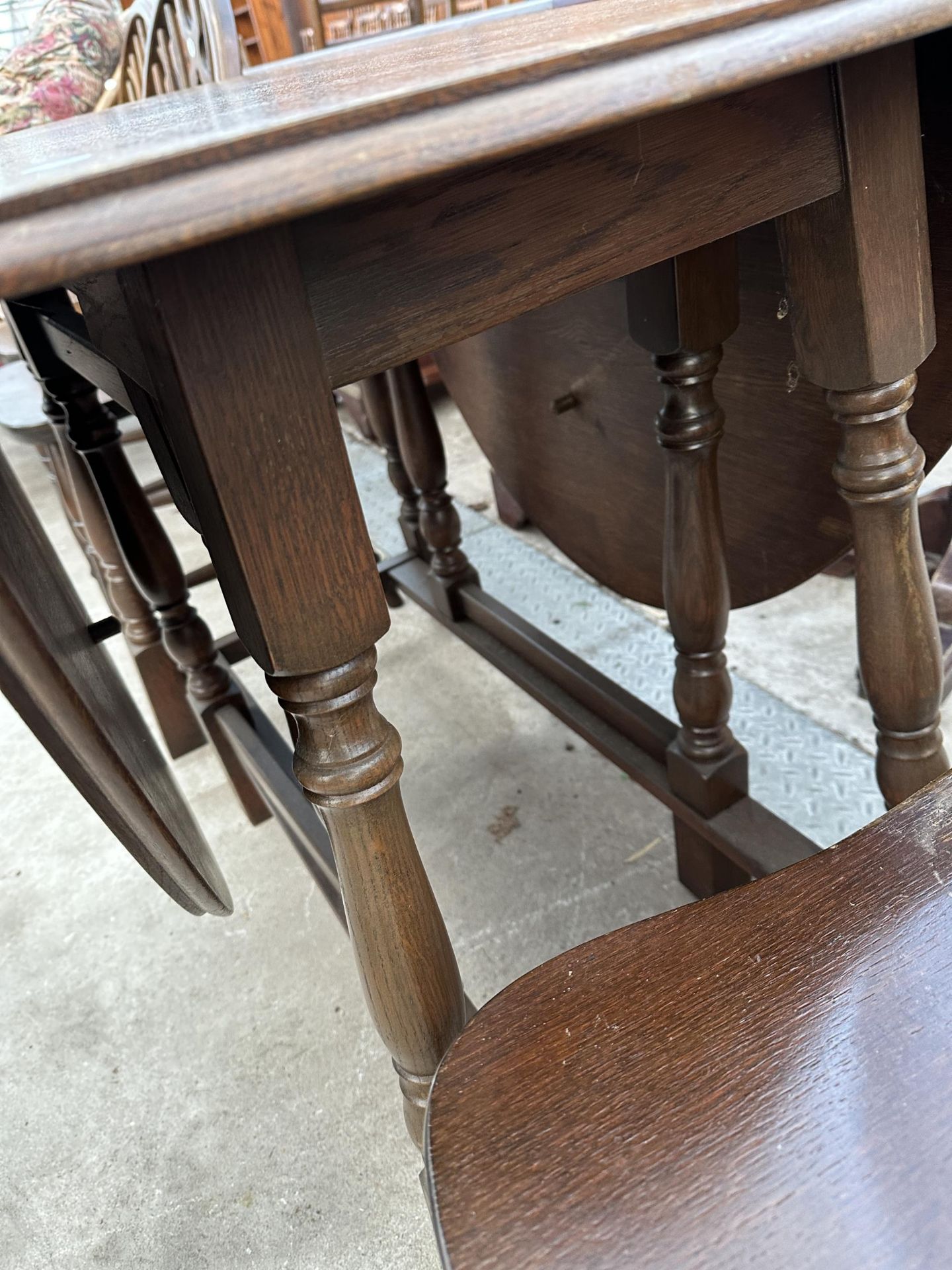 AN OVAL OAK GATELEG DINING TABLE 59" X38" OPENED AND FOUR WHEEL BACK WINDSOR STYLE CHAIRS - Image 5 of 7