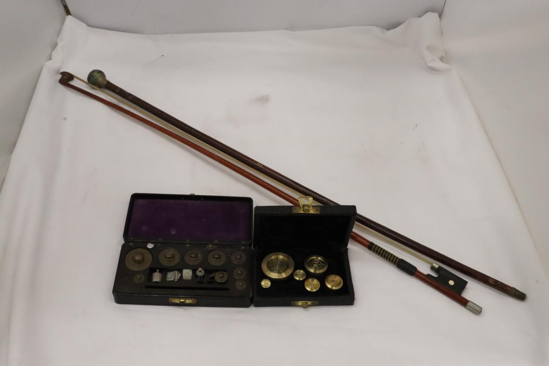 TWO VINTAGE BOXED SETS OF WEIGHTS PLUS A VIOLIN BOW AND A SWAGGER STICK