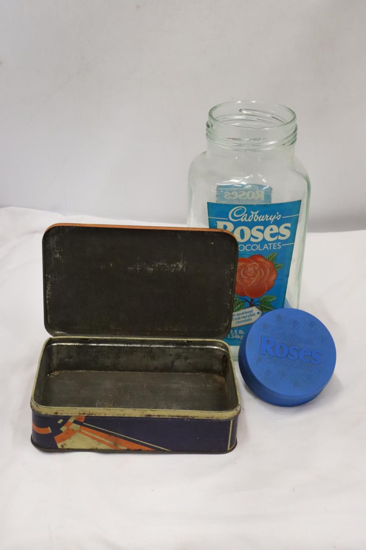A CADBURY'S ROSES CHOCATE SWEET JAR AND A MAISON LYONS CHOCOLATE BISCUITS TIN