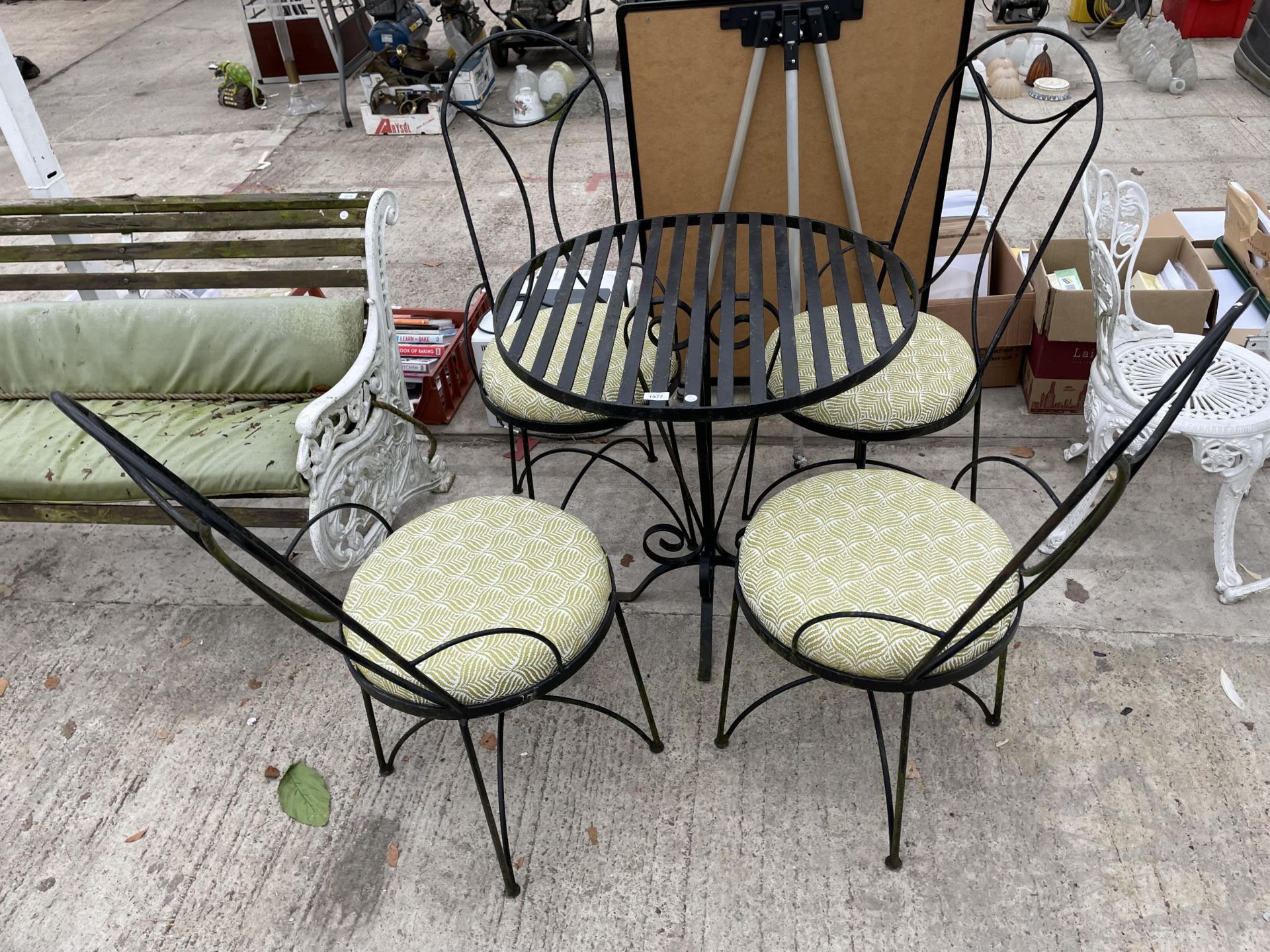 A DECORATIVE METAL PATIO BISTRO SET COMPRISING OF A ROUND TABLE AND FOUR CHAIRS WITH CUSHION SEATS