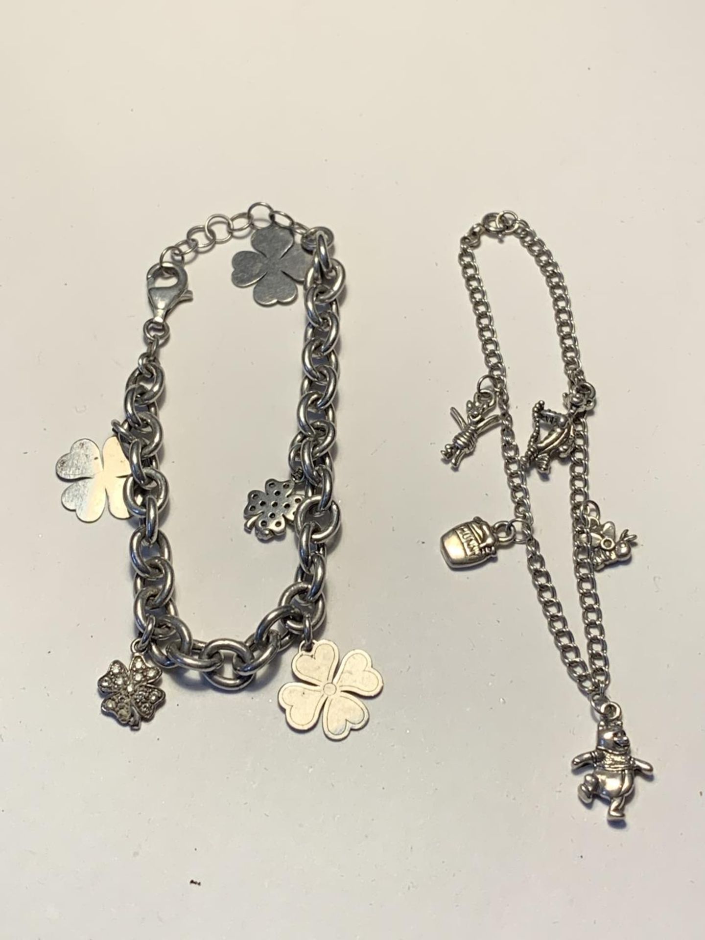 TWO SILVER BRACELETS WITH CHARMS