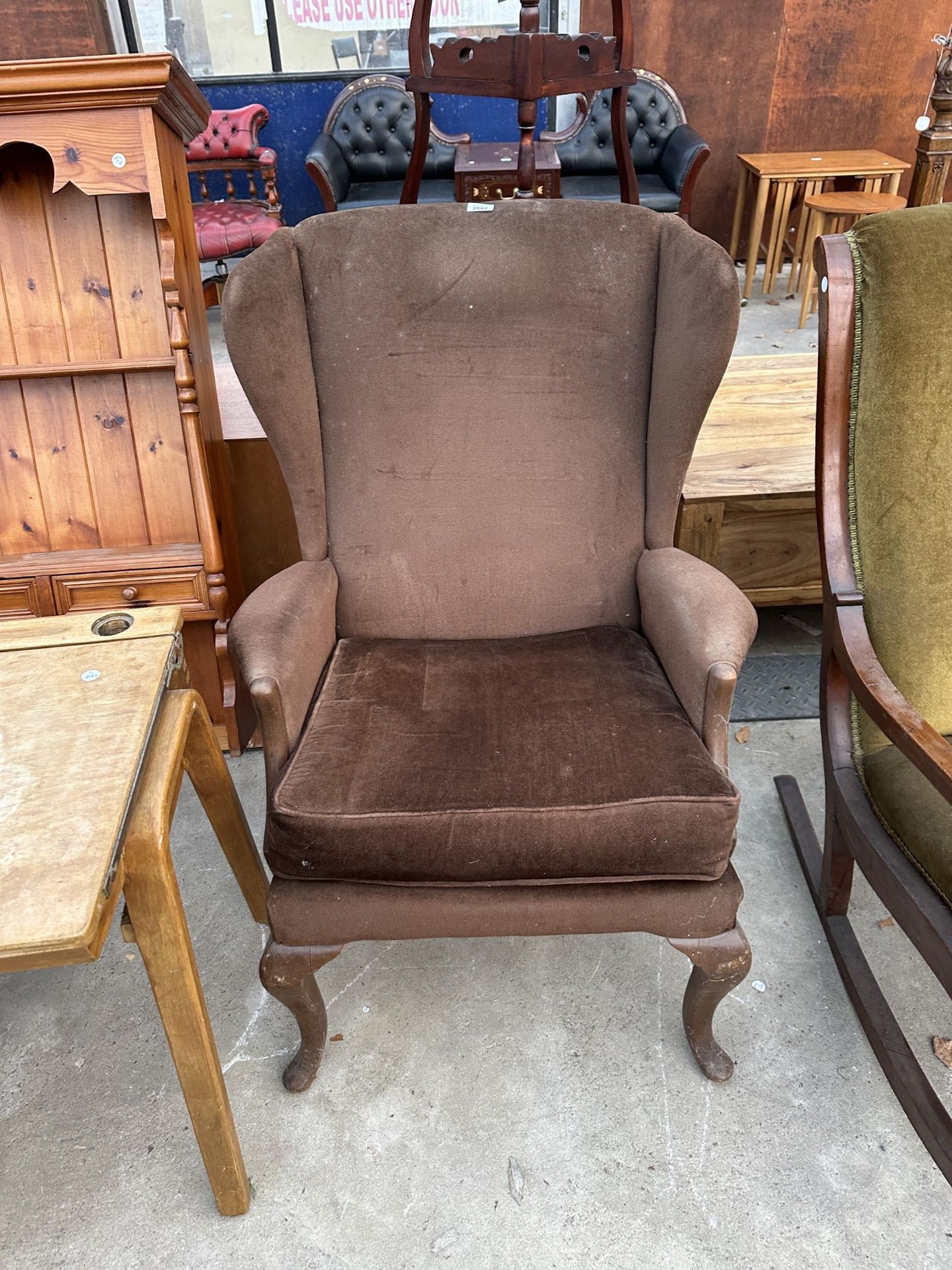 A PARKER KNOLL WINGED FIRESIDE CHAIR ON CABRIOLE FRONT LEGS MODEL NO. PK.918-19