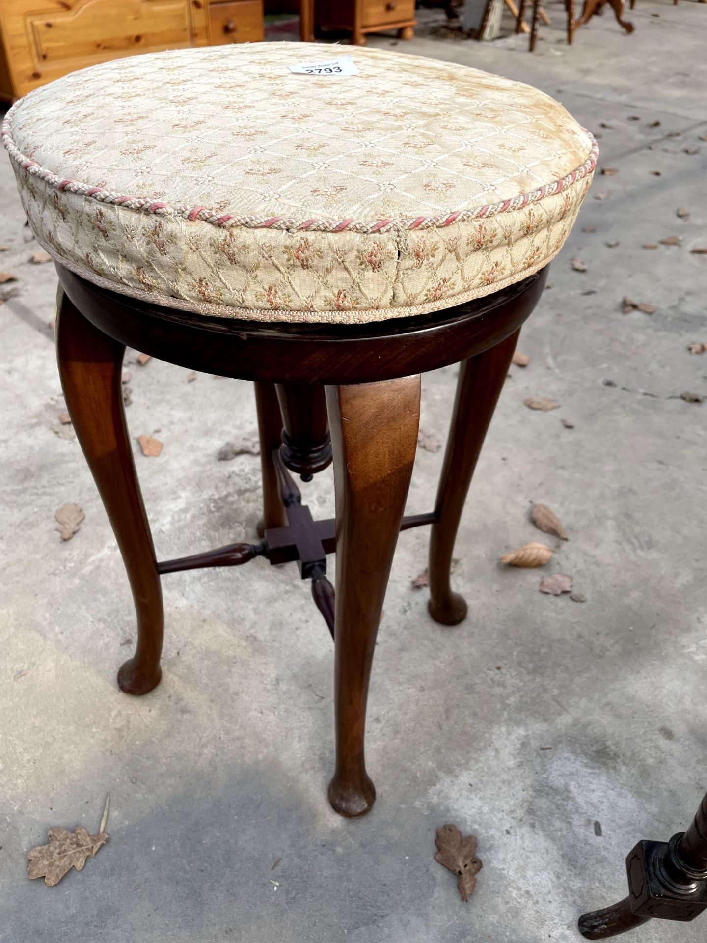 AN EARLY 20TH CENTURY MAHOGANY PIANO STOOL ON CABRIOLE LEGS AND TURNED STRETCHERS