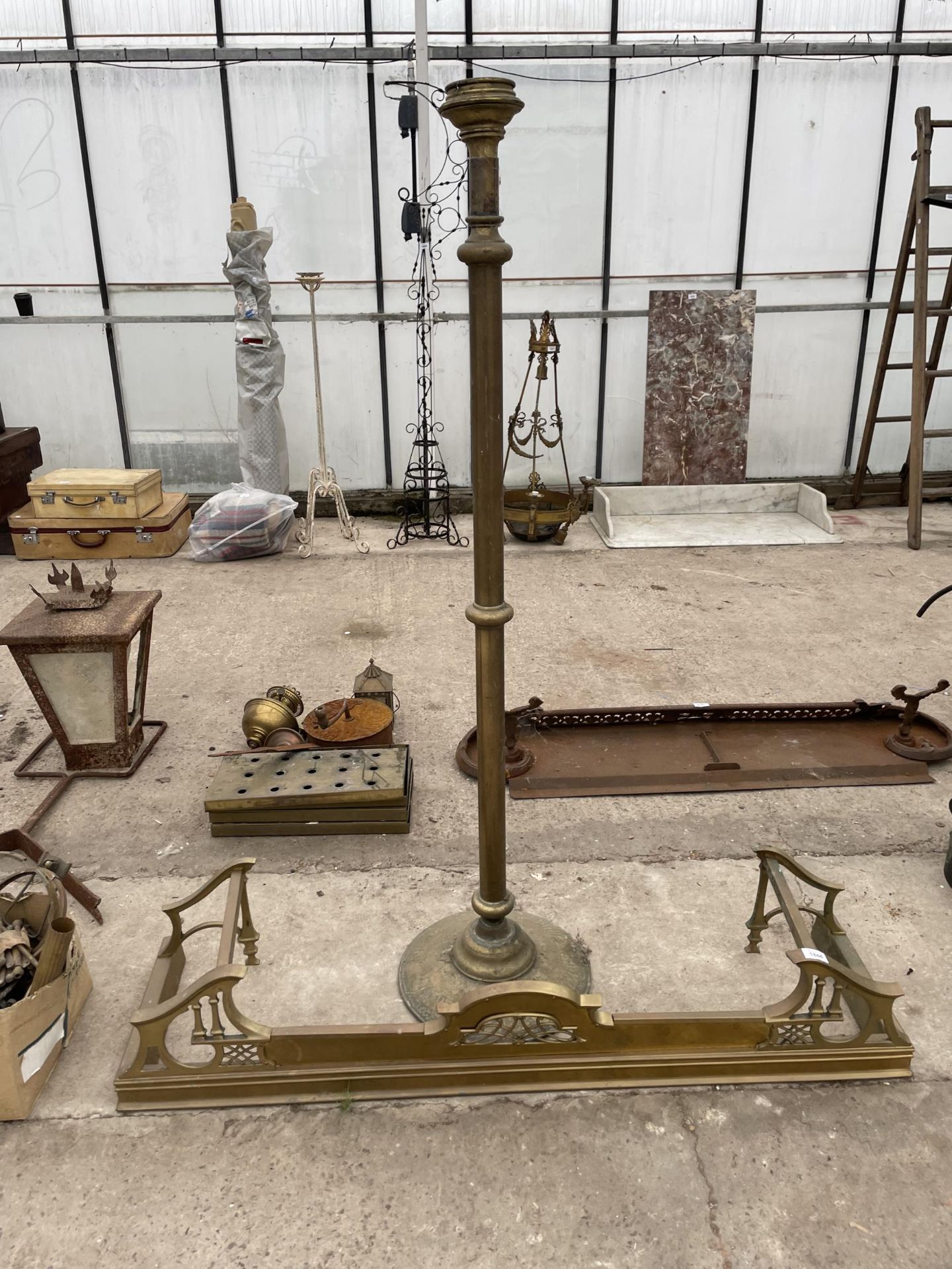 A VINTAGE DECORATIVE BRASS FIRE FENDER AND A BRASS LAMP BASE