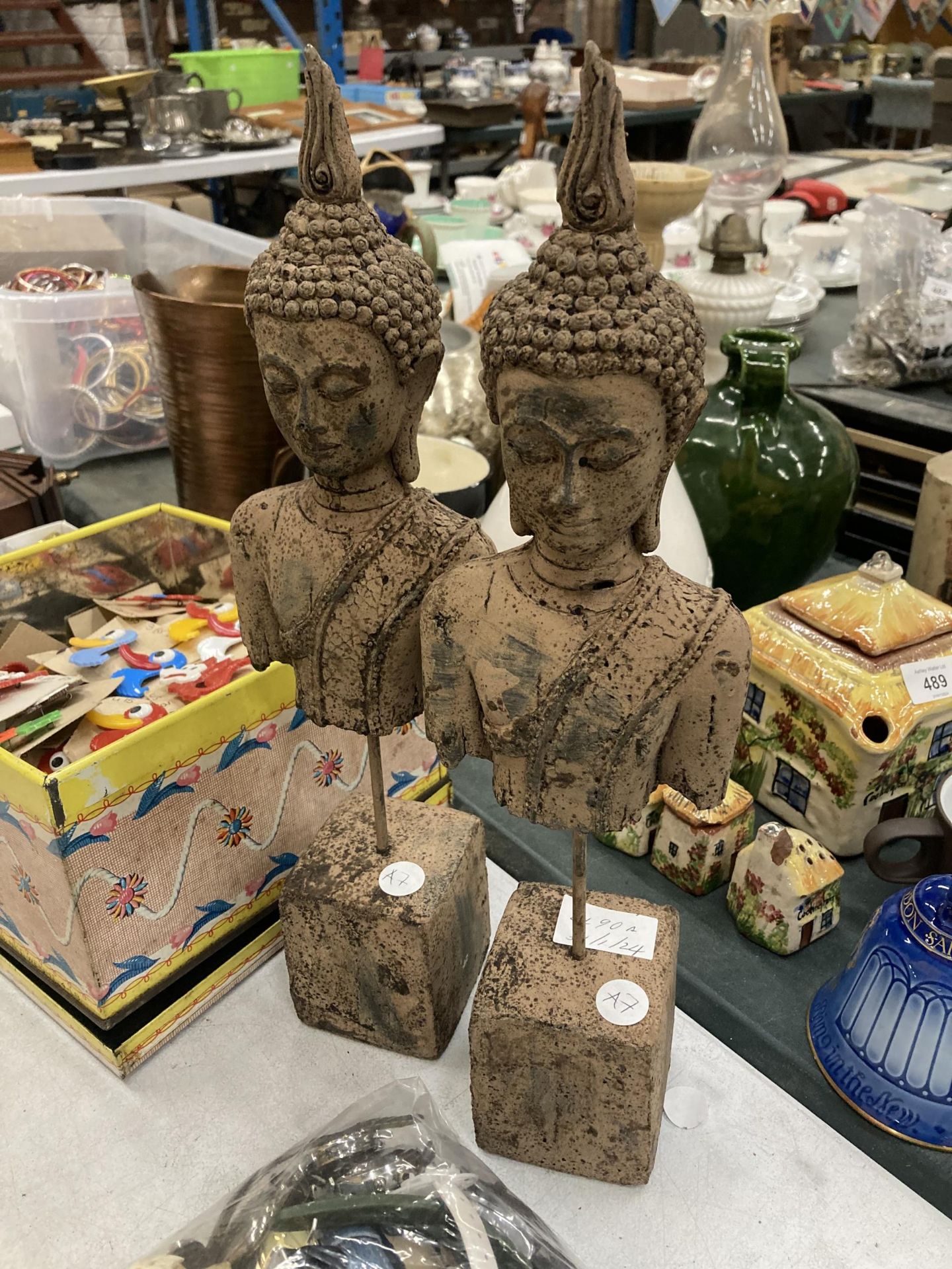 A PAIR OF STONE BUDDAH HEADS ON PLINTHS