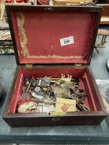 A VINTAGE WOODEN BOX CONTAINING A QUANTITY OF COLLECTABLE ITEMS TO INCLUDE A SKULL, PENS, COSTUME