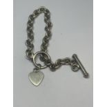 A SILVER T BAR BRACELET WITH HEART CHARM