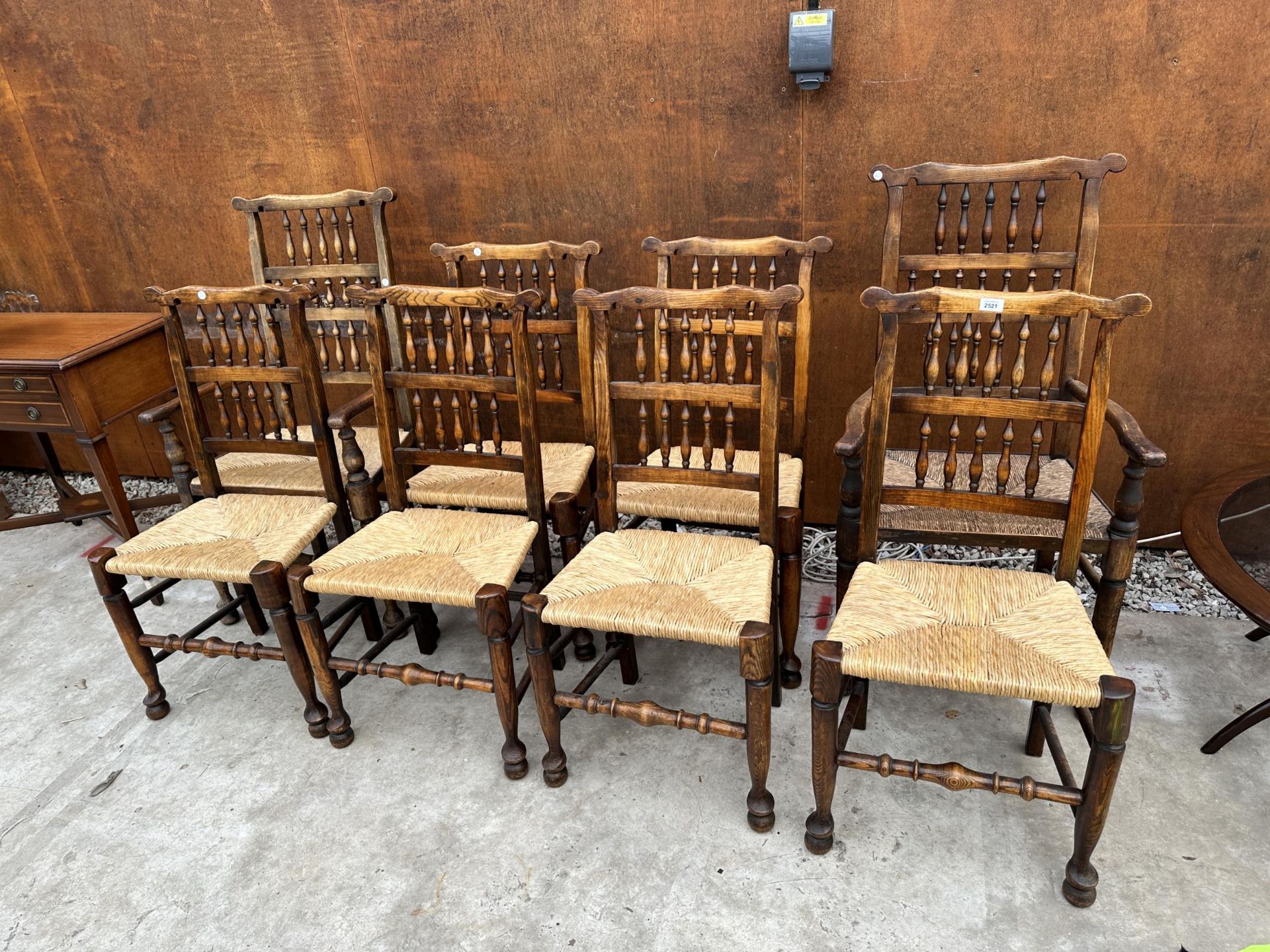 A SET OF EIGHT ELM AND BEECH LANCASHIRE SPINDLE BACK DINING CHAIRS, TWO BEING CARVERS, WITH RUSH