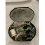 A VINTAGE TIN CONTAINING SEWING ITEMS