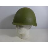 A GREEN PAINTED METAL MILITARY HELMET AND LINING