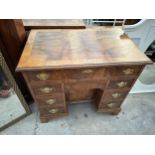 AN 18TH CENTURY STYLE CROSSBANDED WALNUT KNEEHOLE DESK WITH EIGHT DRAWERS AND ONE DOOR HAVING