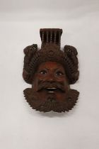 AN ASIAN STYLE CARVED WOODEN MASK