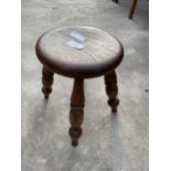 A SMALL ELM STOOL ON TURNED LEGS